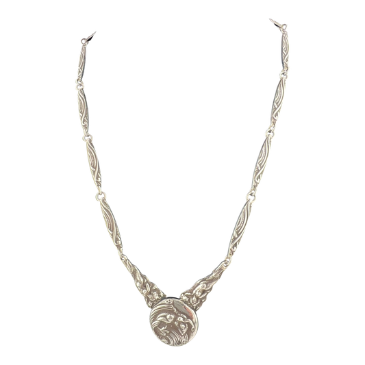 Silver necklace with mermaid design on a white background