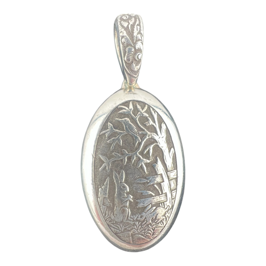 Rabbit and bird in a garden with trees fine silver pendant